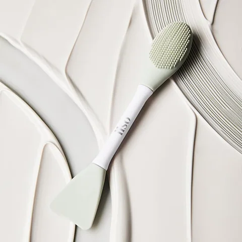 Dual Clean Brush resting beside a wash-off mask